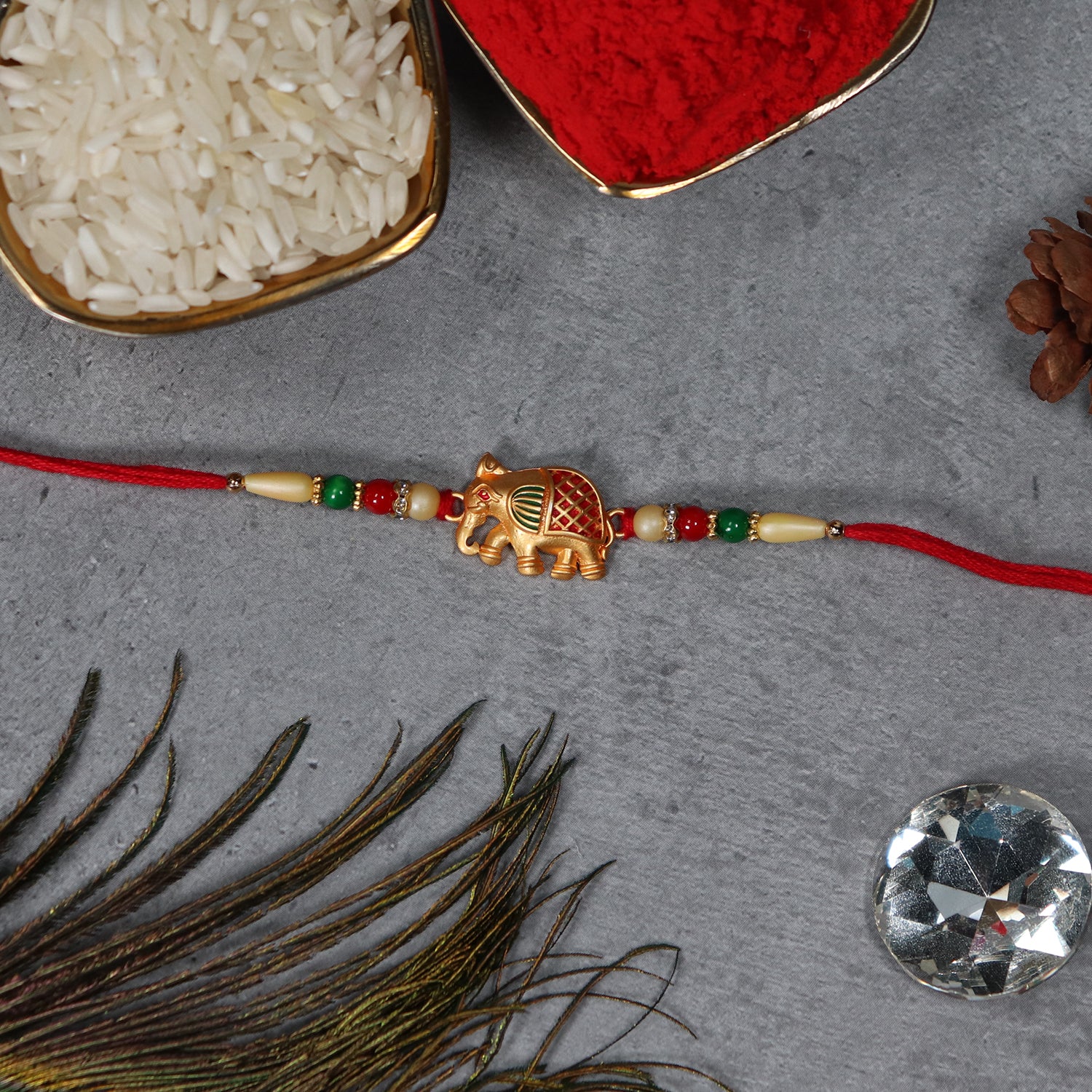 Golden Elephant Rakhi With Red Green Moti Golden Elephant Rakhi With Red Green Moti